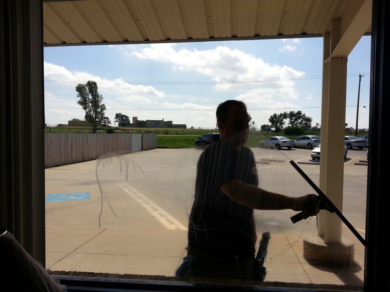 Eric scrubbing a window from inside